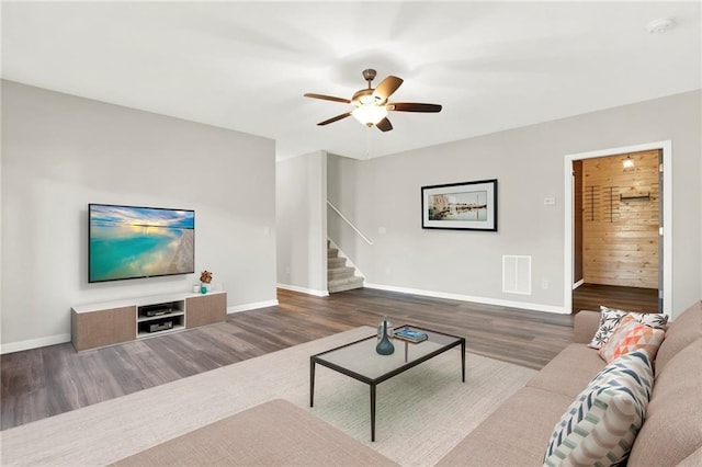 living room featuring dark wood-type flooring and ceiling fan