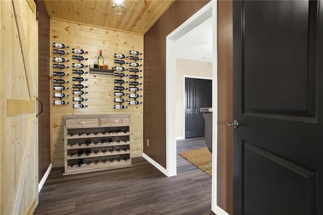 wine area with wood ceiling, wooden walls, and dark wood-type flooring