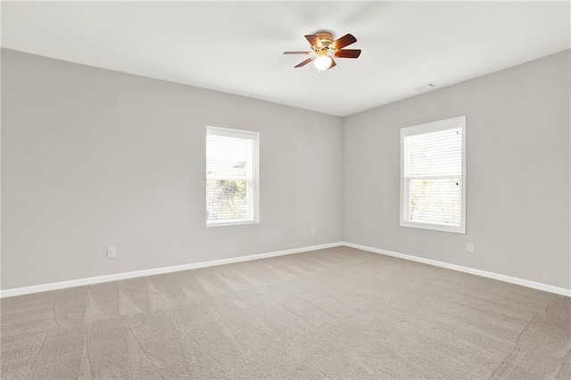 carpeted spare room with ceiling fan and a healthy amount of sunlight