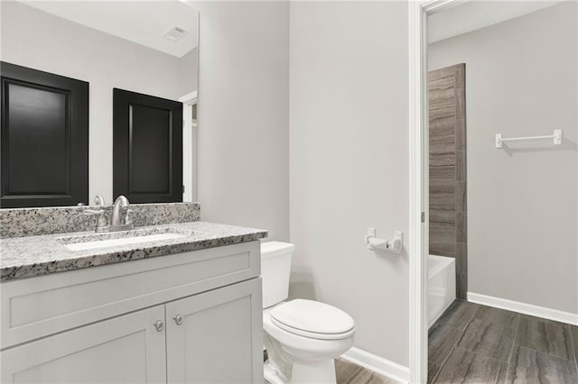 full bathroom featuring vanity, hardwood / wood-style flooring, bathtub / shower combination, and toilet