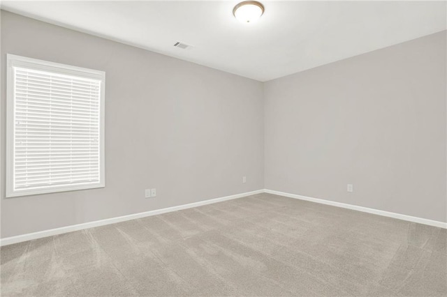 unfurnished room featuring light carpet