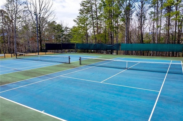 view of tennis court featuring basketball hoop