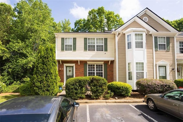 townhome / multi-family property featuring uncovered parking and brick siding