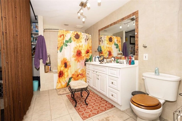 full bath with tile walls, tile patterned flooring, toilet, and vanity