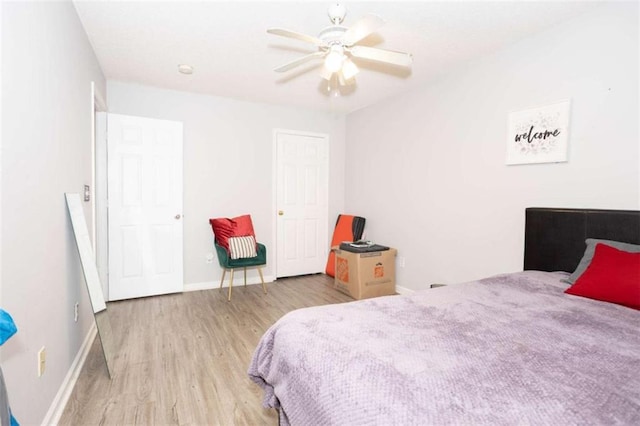 bedroom with wood finished floors, baseboards, and a ceiling fan