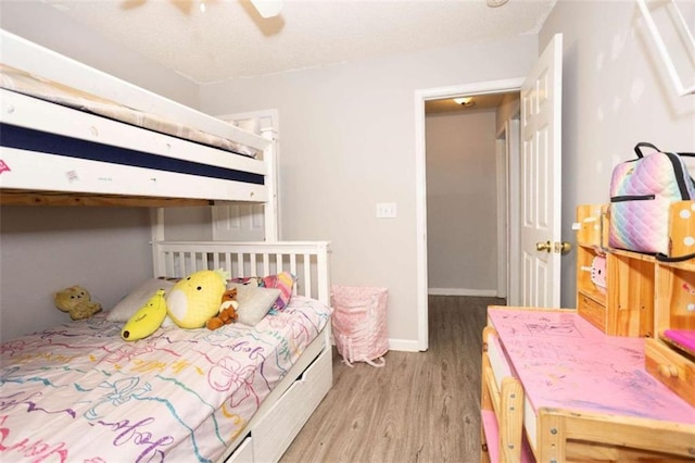 bedroom with light wood-style flooring, baseboards, and a ceiling fan