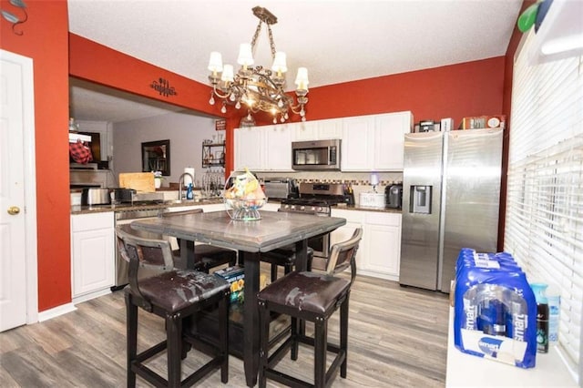 dining area featuring light wood finished floors, a chandelier, and plenty of natural light