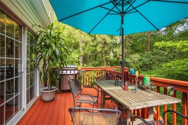 wooden deck featuring grilling area and outdoor dining area