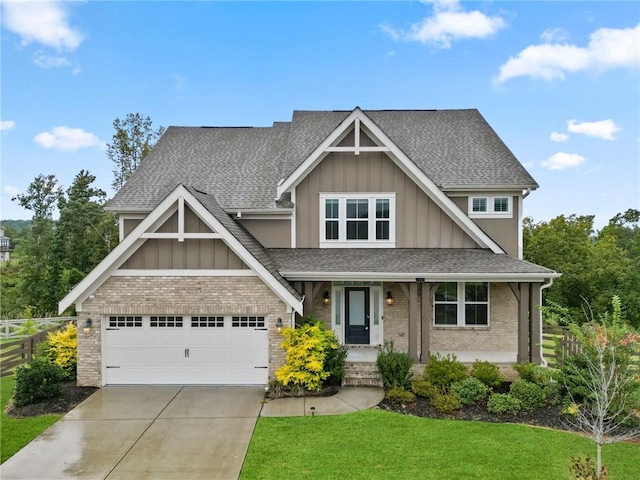 craftsman inspired home featuring board and batten siding, concrete driveway, a front yard, roof with shingles, and brick siding