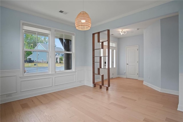 spare room featuring plenty of natural light, visible vents, and light wood finished floors