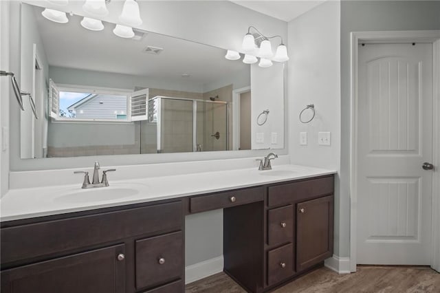 bathroom with a shower stall, double vanity, visible vents, and a sink