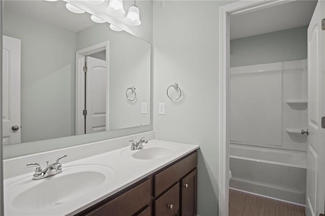 bathroom with double vanity, shower / bath combination, and a sink