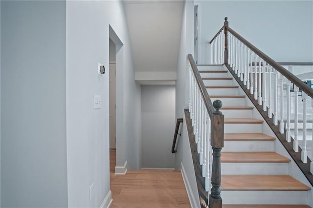 stairs with wood finished floors and baseboards