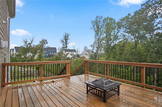 wooden terrace with a fire pit and a residential view