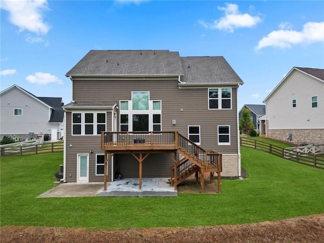 back of house featuring a lawn, a deck, a fenced backyard, stairway, and a patio area