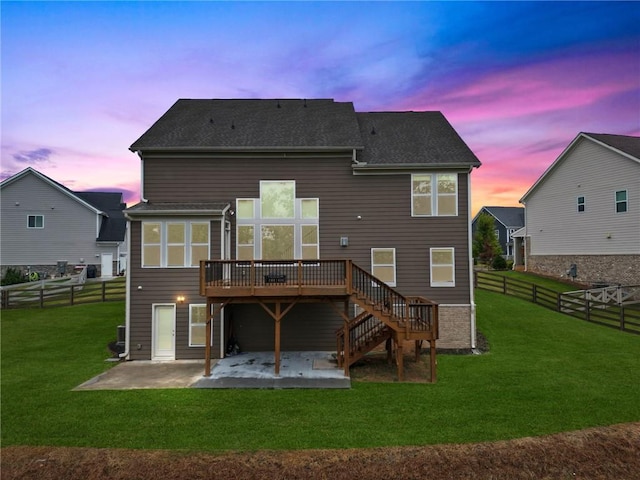 back of house featuring a lawn, a deck, a fenced backyard, stairs, and a patio area