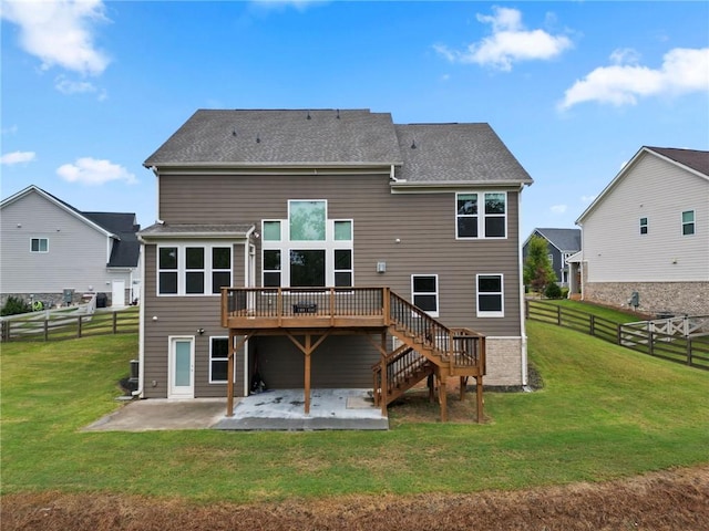 rear view of house featuring a yard, a deck, stairs, and a patio area