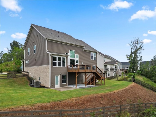 back of house with fence, stairway, a wooden deck, a lawn, and a patio area