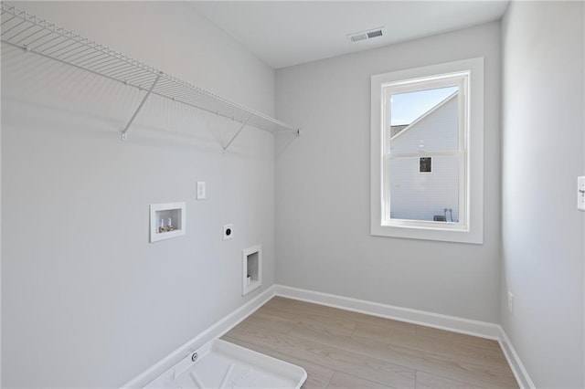 laundry room with electric dryer hookup, washer hookup, light wood-type flooring, and baseboards