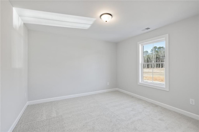 carpeted spare room featuring baseboards