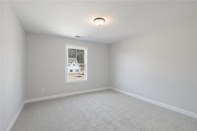 spare room featuring carpet and baseboards