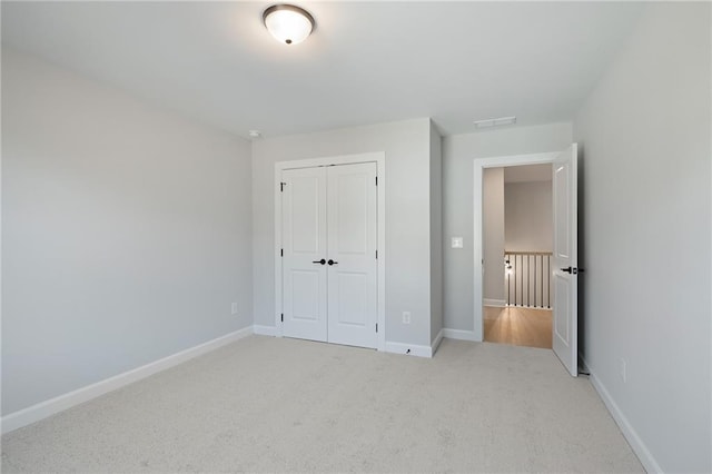 unfurnished bedroom featuring carpet floors, a closet, and baseboards
