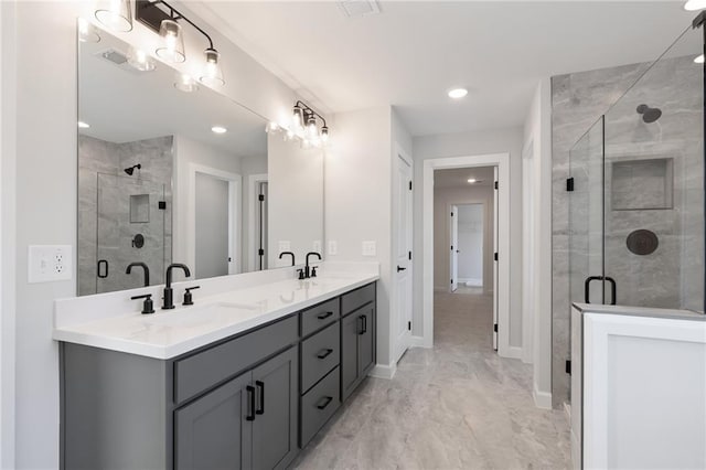 bathroom with a shower stall, double vanity, baseboards, recessed lighting, and marble look tiles