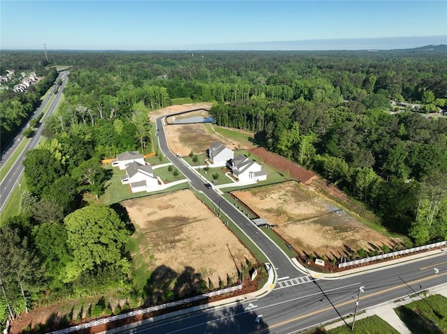 aerial view of property and surrounding area featuring a heavily wooded area