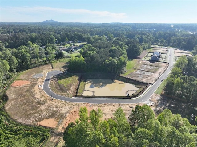 aerial view of property's location featuring a forest