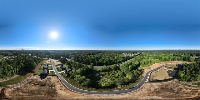 aerial view of property's location featuring a forest