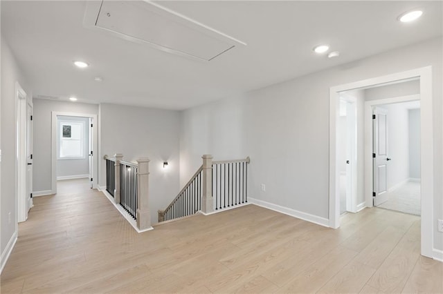 hall featuring attic access, an upstairs landing, light wood-type flooring, baseboards, and recessed lighting