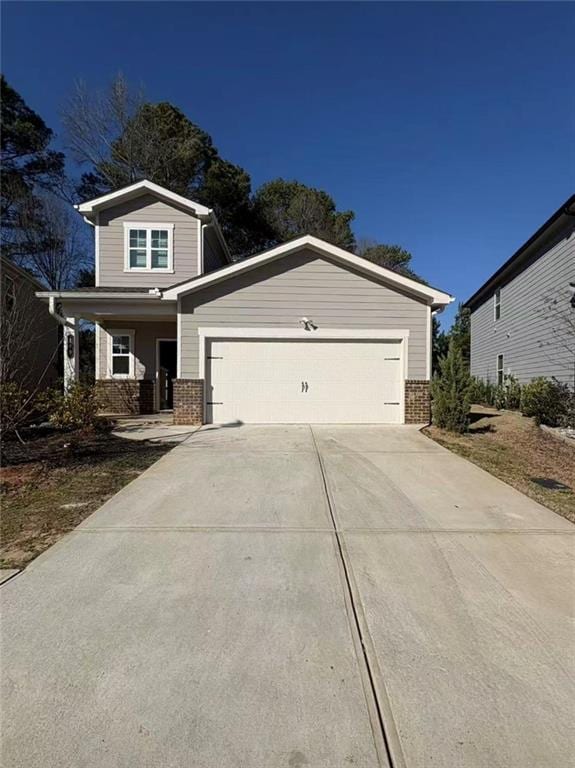 view of front of home featuring concrete driveway, brick siding, and an attached garage