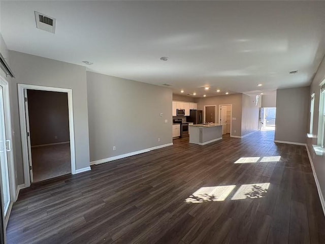 unfurnished living room with dark wood-style floors, recessed lighting, visible vents, and baseboards