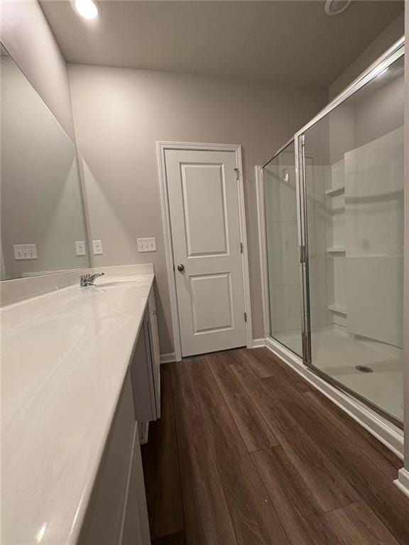 full bathroom featuring recessed lighting, wood finished floors, vanity, and a shower stall