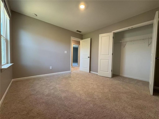 unfurnished bedroom featuring carpet floors, a closet, visible vents, and baseboards