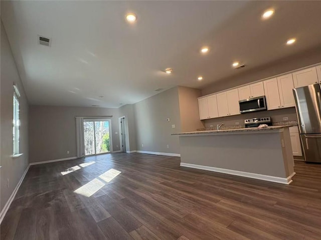 kitchen featuring stainless steel appliances, dark wood-type flooring, visible vents, white cabinetry, and open floor plan