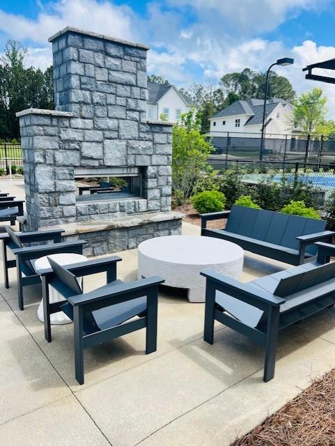 6930 Pond View Dr, Cumming, GA 30028 - view of patio with an outdoor stone fireplace and fence