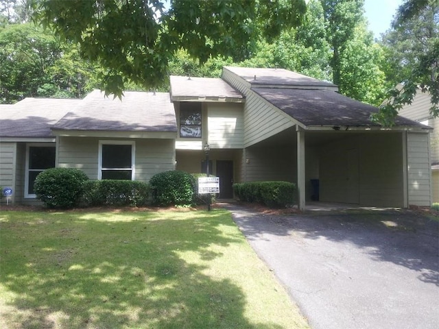 view of front of house with a carport and a front lawn