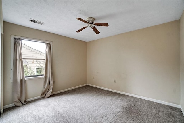 spare room with visible vents, ceiling fan, carpet floors, and baseboards