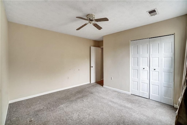 unfurnished bedroom featuring carpet flooring, a closet, ceiling fan, visible vents, and baseboards