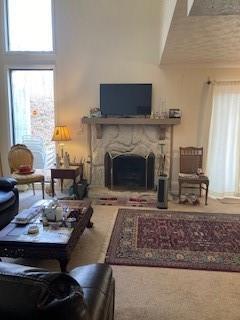 living room featuring a towering ceiling and a fireplace