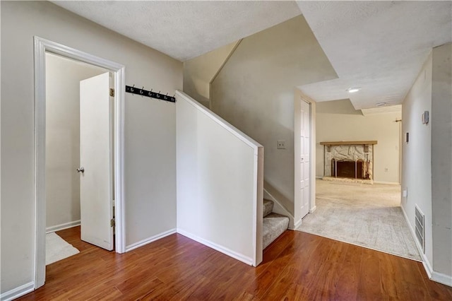 interior space with stairs, visible vents, wood finished floors, and a fireplace