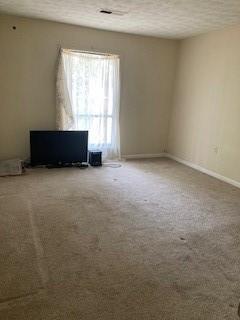 carpeted empty room with a textured ceiling