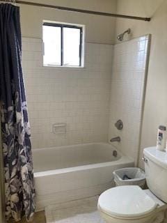 bathroom featuring toilet and shower / bath combo with shower curtain