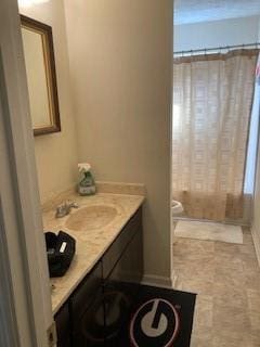 bathroom featuring vanity, curtained shower, and toilet