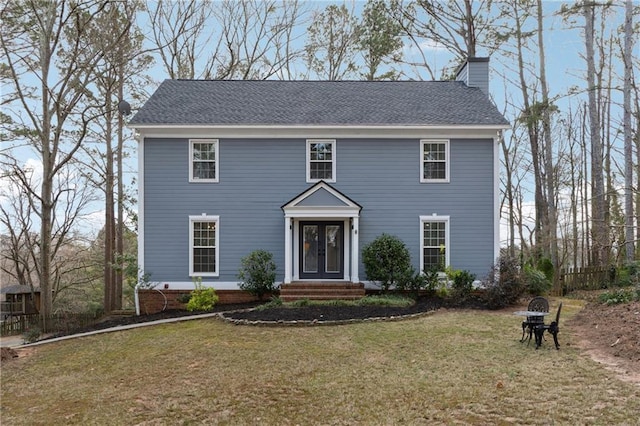 colonial inspired home featuring a front lawn and a chimney