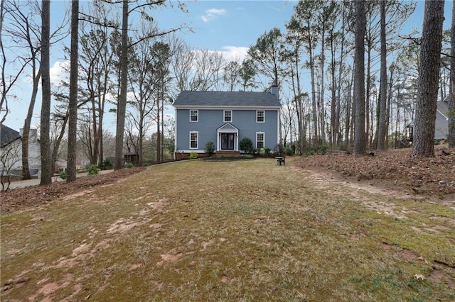 view of front of house with a front yard and a chimney