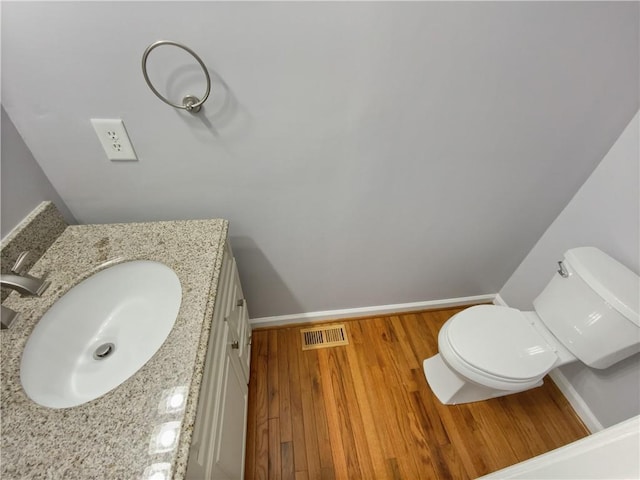 93 Wolfridge Ct, Dallas, GA 30132 - bathroom featuring visible vents, toilet, wood finished floors, baseboards, and vanity