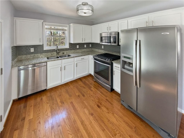 93 Wolfridge Ct, Dallas, GA 30132 - kitchen featuring a sink, white cabinetry, appliances with stainless steel finishes, light wood finished floors, and decorative backsplash