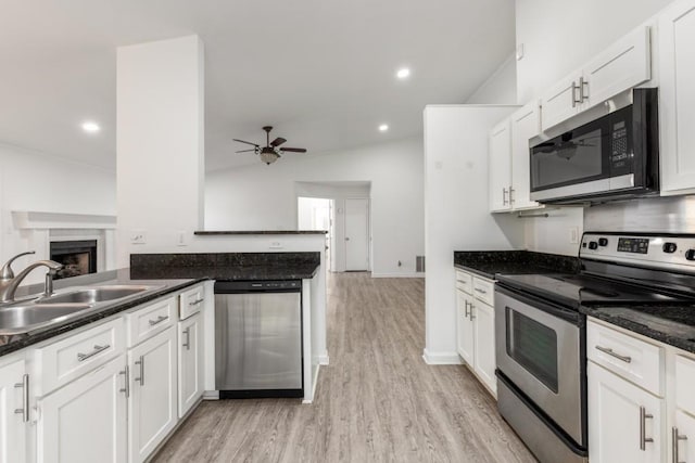 kitchen with a ceiling fan, appliances with stainless steel finishes, white cabinets, and a sink